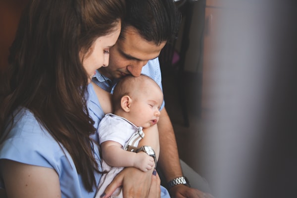 Părinți cu bebelușul dormind