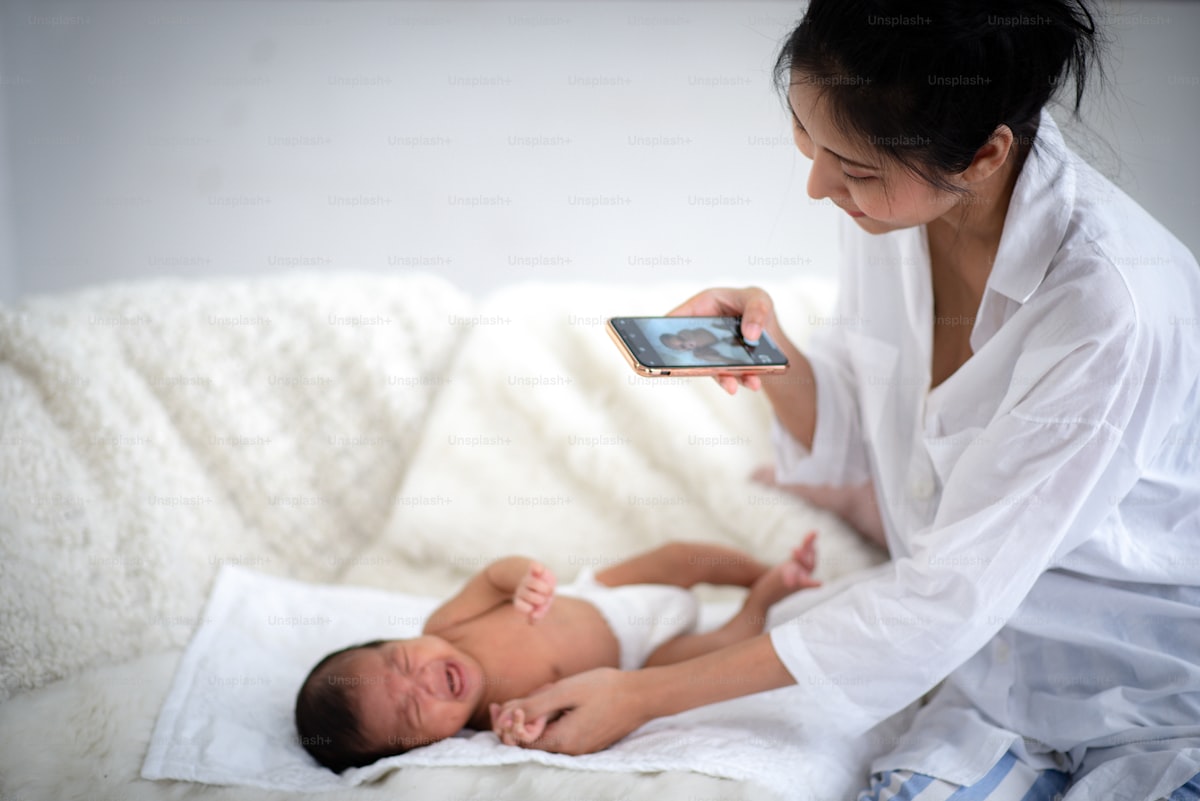 Mamă cu bebelușul folosind telefonul